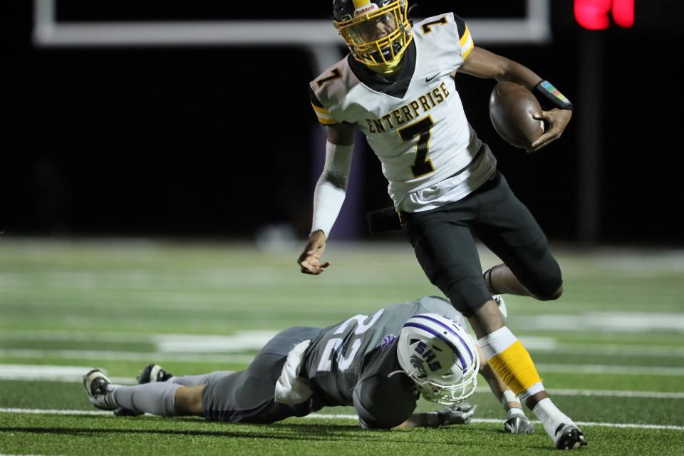 Enterprise quarterback Jaylen Johnson (7) runs for a first down against Shasta’s Carter Oliver (22) in the first quarter of the River Bowl on Friday, Oct. 14, 2022 in Thompson Field. The Hornets defeated the Wolves 41-14 in River Bowl XXX, a tradition of the rivalry between the two Redding schools.