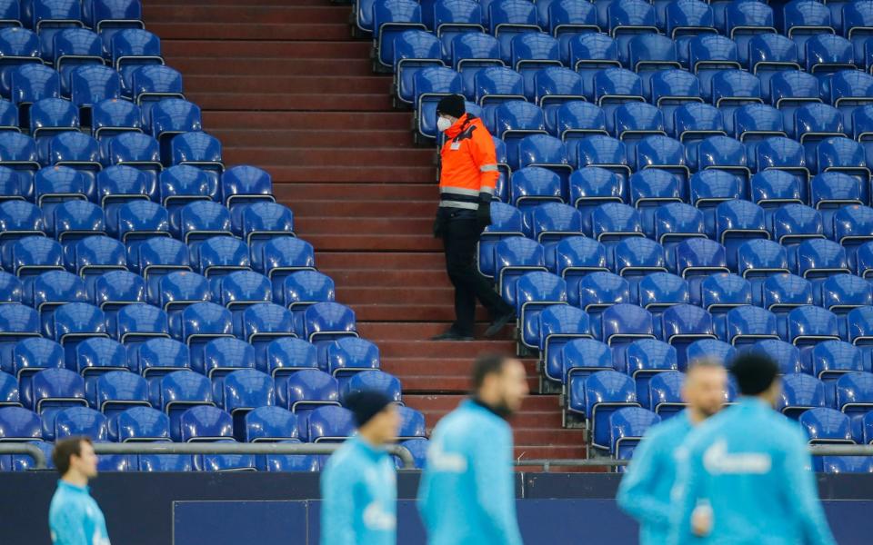 General view of a steward wearing a protective face mask standing by empty seats inside the stadium - REUTERS