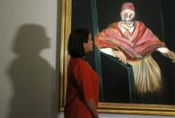 A Sotheby's employee poses with "Study for a Pope I" by Francis Bacon at Sotheby's in London, Britain June 19, 2015. REUTERS/Suzanne Plunkett