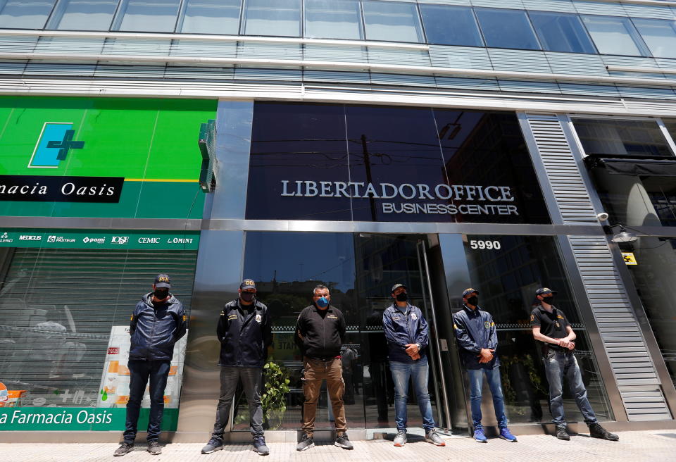 Police officers stand guard outside the building where Leopoldo Luque, the personal doctor of late soccer legend Diego Maradona, has his office in Buenos Aires. (Reuters/Agustin Marcarian)