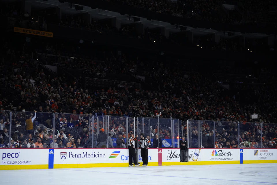 Officials talk during a partial power outage in the first period of an NHL hockey game between the Philadelphia Flyers and the Tampa Bay Lightning, Tuesday, Feb. 27, 2024, in Philadelphia. (AP Photo/Matt Slocum)