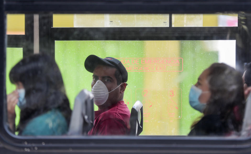 Personas usan mascarillas a bordo de un autobús para evitar la propagación del nuevo coronavirus en Ciudad de México, el martes 31 de marzo de 2020. (AP Foto / Eduardo Verdugo)