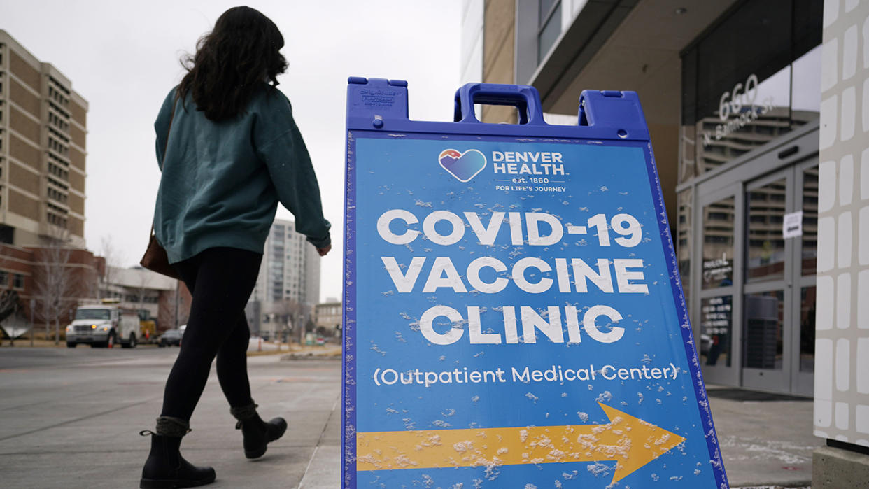 A woman walks past a sign reading 