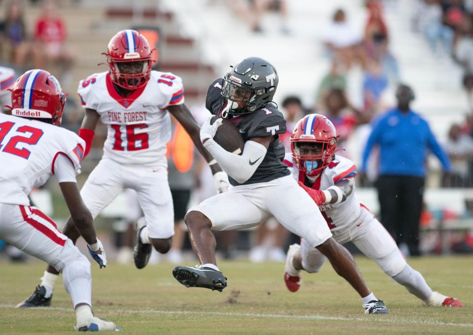 Christian Neptune (1) carries the ball during the Pine Forest vs Tate football game at Tate High School in Cantonment on Friday, Aug. 25, 2023.