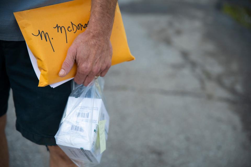 Craig Coburn-McDonald holds medical inhalers and medical forms for Melissa McDonald after she is officially signed out of her room at Portage Manor, outside of Portage Manor, on Monday July 31, 2023.