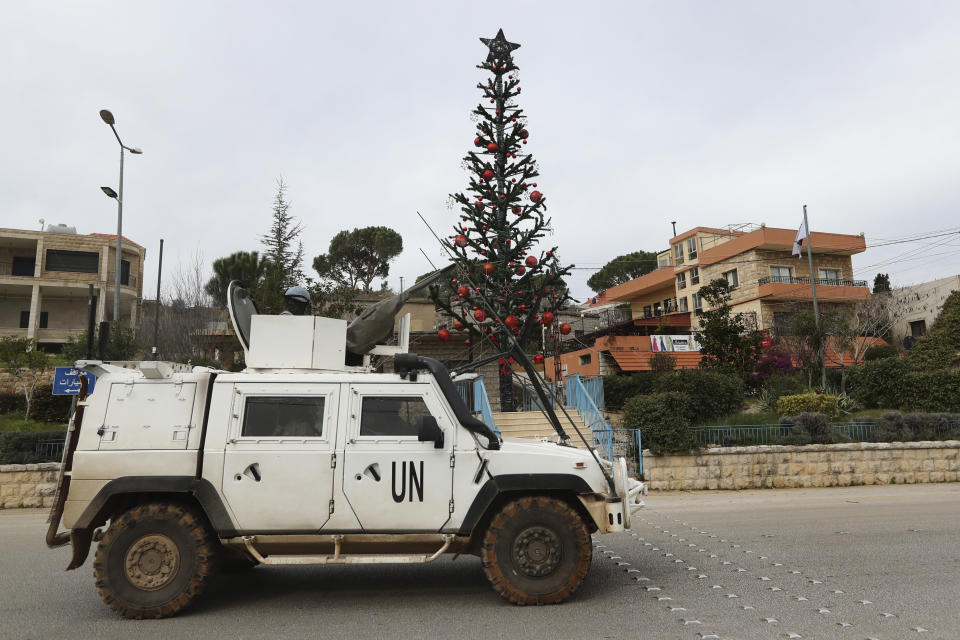 A U.N peacekeeper vehicle passes next of a Christmas tree that set in Marjayoun square, a town near the Lebanese Israeli border, south Lebanon, on Thursday, Dec. 21, 2023. Christians in the border villages of south Lebanon prepared for a subdued Christmas under the shadow of the ongoing war in Gaza and its spillover in Lebanon.(AP Photo/Mohammed Zaatari)