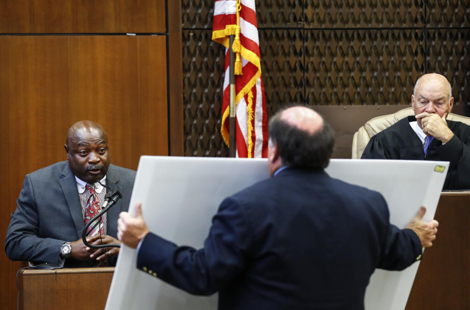 CORRECTS JUDGE LAST NAME TO CHATHAM NOT CHATMAN - Judge Gerald Gerald Chatham, right, listens as lead prosecutor John Champion, center, questions witness Lt. Edward Dickson on the second day of the retrial of Quinton Tellis in Batesville, Mississippi on Wednesday, Sept. 26, 2018. Tellis is charged with burning 19-year-old Jessica Chambers to death almost three years ago on Dec. 6, 2014. He has pleaded not guilty to the murder. (Mark Weber/The Commercial Appeal via AP, Pool)