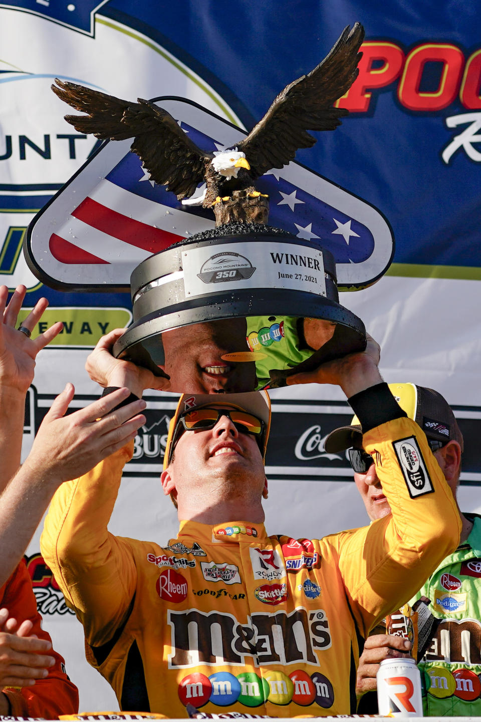 Kyle Busch raises the trophy after winning a NASCAR Cup Series auto race at Pocono Raceway, Sunday, June 27, 2021, in Long Pond, Pa. (AP Photo/Matt Slocum)