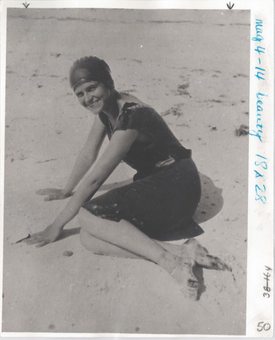 A woman poses on the beach in the early 1900s.