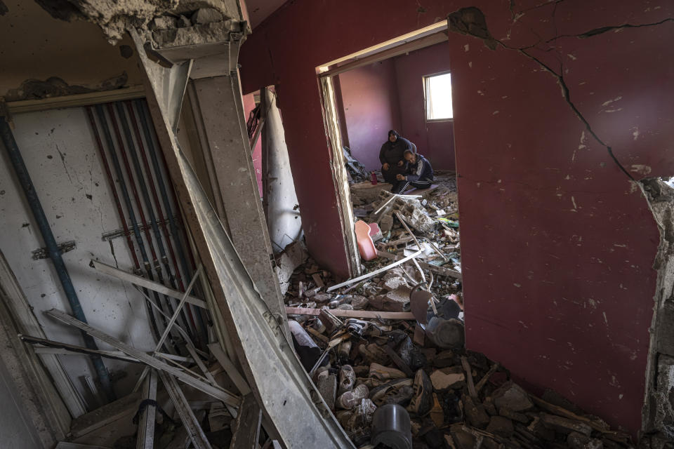 Palestinians sit in their house after it was hit by an Israeli strike on the Gaza Strip in Khan Younis, Saturday, Nov. 18, 2023. (AP Photo/Fatima Shbair)