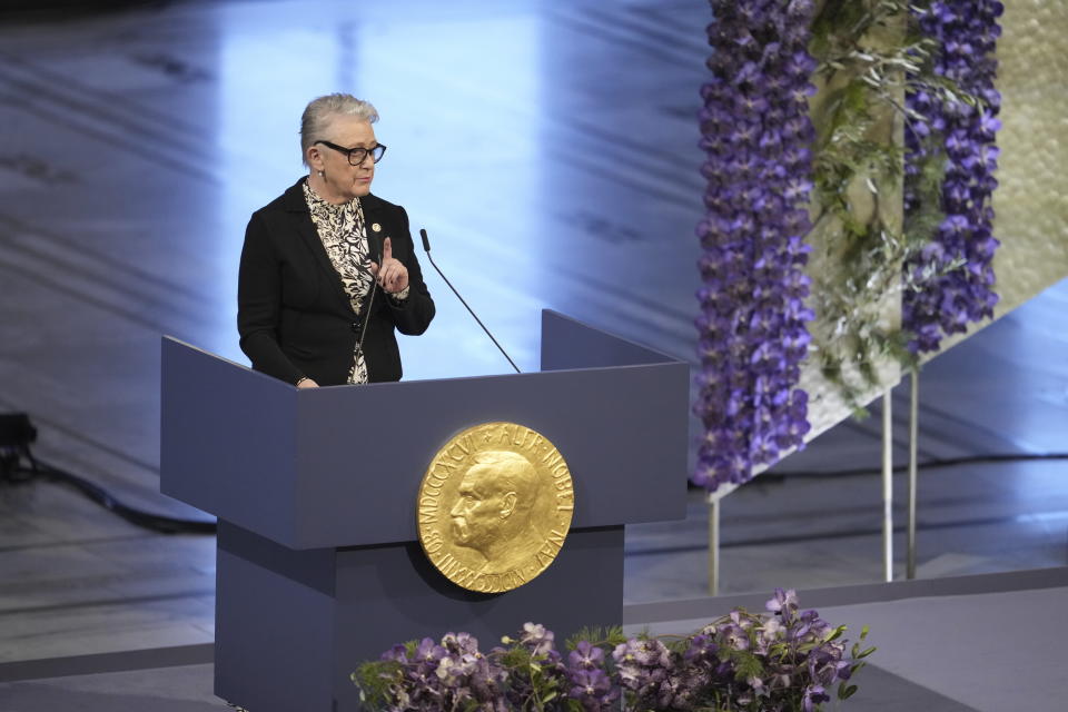 Chairman of the Nobel Committee Berit Reiss-Andersen speaks during the awarding of the Nobel Peace Prize for 2023 in Oslo City Hall, Oslo, Norway, Sunday, Dec. 10, 2023. The children of imprisoned Iranian activist Narges Mohammadi, shown on the screen, are set to accept this year’s Nobel Peace Prize on her behalf. Mohammadi is renowned for campaigning for women’s rights and democracy in her country. (Fredrik Varfjell/NTB via AP)