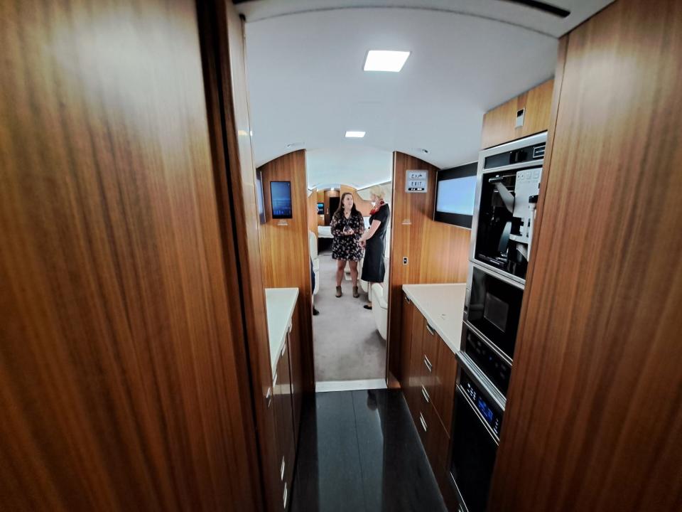 Passengers walk through the galley to enter the main cabin.