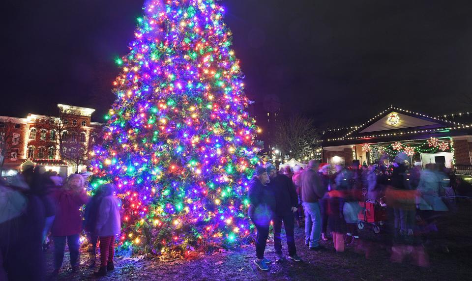 Michelle and John Dalton of Erie, center, have their picture taken with the Christmas tree at Perry Square, Dec. 3, 2021, during the Downtown D'Lights celebration, which included the lighting of the Perry Square decorations and a visit from Santa Claus.