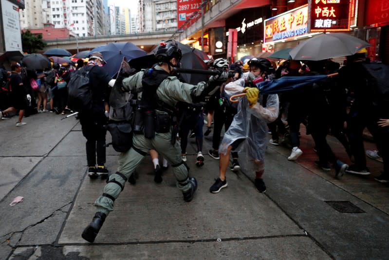 FILE PHOTO: A riot police officer clashes with a protester during an anti-government rally in central Hong Kong