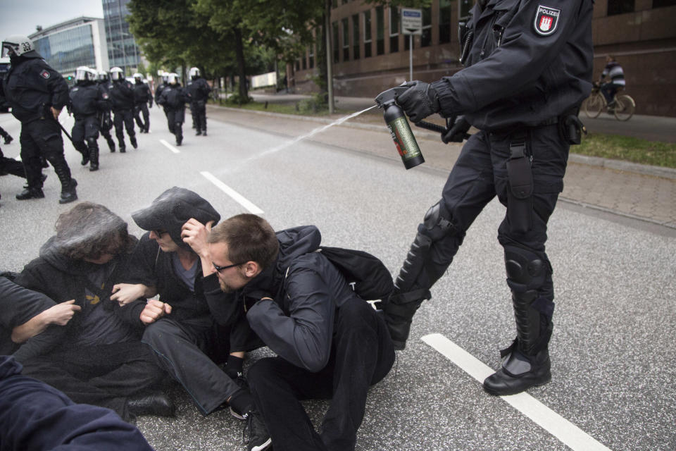 Policeman use pepper spray on protesters.