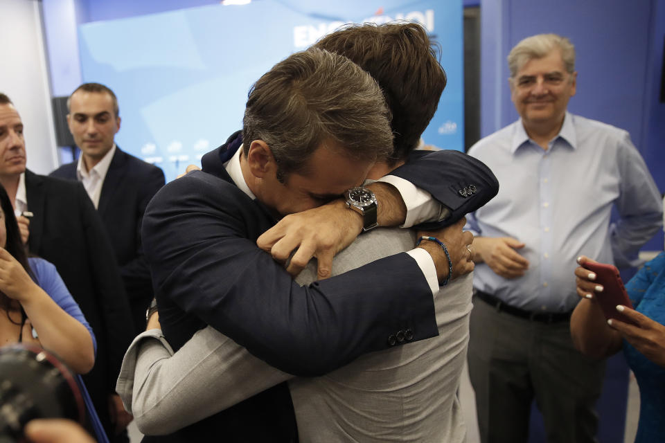 Greek opposition New Democracy conservative party leader Kyriakos Mitsotakis embrace his son after win the parliamentary elections at the New Democracy headquarters in Athens, on Sunday, July 7, 2019. Official results from nearly 60% of ballots counted showed the conservative New Democracy party of Kyriakos Mitsotakis winning comfortably with 39.7% compared to Tsipras' Syriza party with 31.5%. (AP Photo/Thanassis Stavrakis)