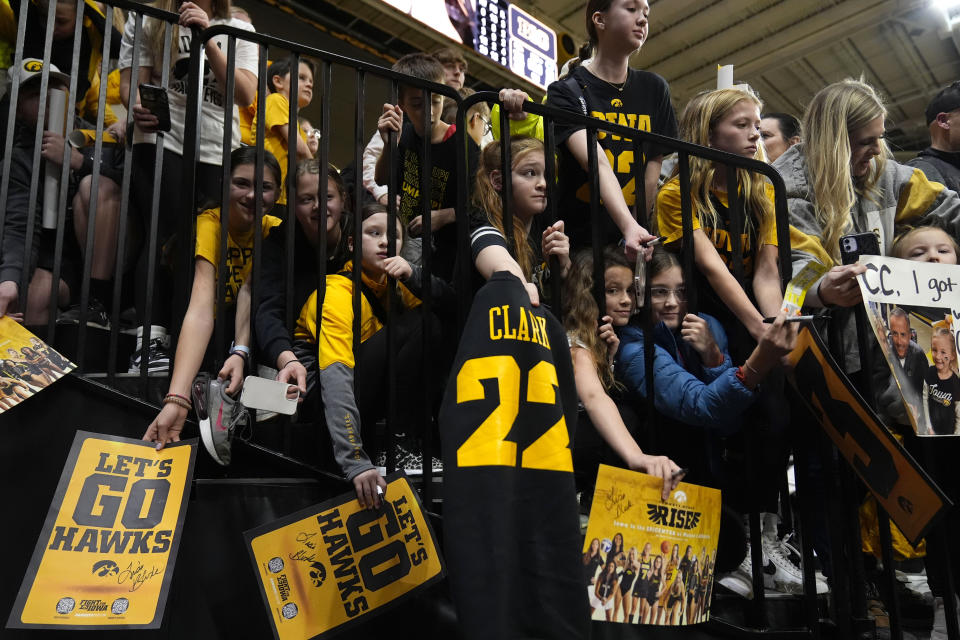 FILE - Fans wait to get an autograph from Iowa guard Caitlin Clark after an NCAA college basketball game between Iowa and Penn State, Thursday, Feb. 8, 2024, in Iowa City, Iowa. As Clark has become the face of women's basketball, her face is everywhere. She has lucrative NIL deals with Nike, Gatorade, Buick and was featured in a State Farm commercial with Jimmy Butler and Reggie Miller. . (AP Photo/Charlie Neibergall, File)