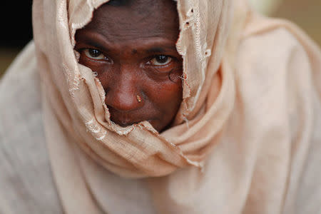 A Rohingya refugee woman waits for humanitarian aid to be distributed at a camp for those who recently fled from Myanmar, near Cox's Bazar, Bangladesh October 5, 2017. REUTERS/Damir Sagolj