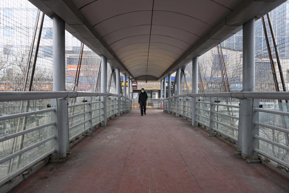 Ein einsamer Passant auf einer Fußgänger-Überführung in Peking. (Bild: Greg Baker/AFP)