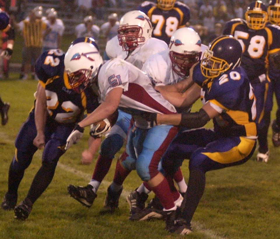 St.Joe's #9 Dan Kobyra gets tackled by Clay's #22 Adam O'Neil and #20 Tony Iorio during first half action at Clay Field Friday Eveneing. Gene Kaiser photo Sports folder Aug 23,2002