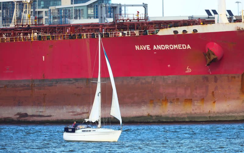 A sailboat passes in front of the Liberia-flagged oil tanker Nave Andromeda at Southampton Docks, following a security incident aboard the ship the night before off the coast of Isle of Wight, in Southampton