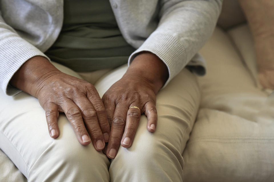 Cropped shot of a senior woman's hands resting in her sofa.
