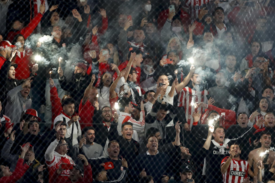 FILE - Argentina's Estudiantes de la Plata fans cheer their team during a Copa Libertadores soccer match against Uruguay's Nacional in Montevideo, Uruguay, Wednesday, April 13, 2022. As coronavirus cases increase during 2022 in places like China, where authorities are implementing a new round of lockdowns, Latin American countries are eliminating restrictions on mass gatherings and stopping mask mandates that have lasted for two years. (AP Photo/Matilde Campodonico, File)