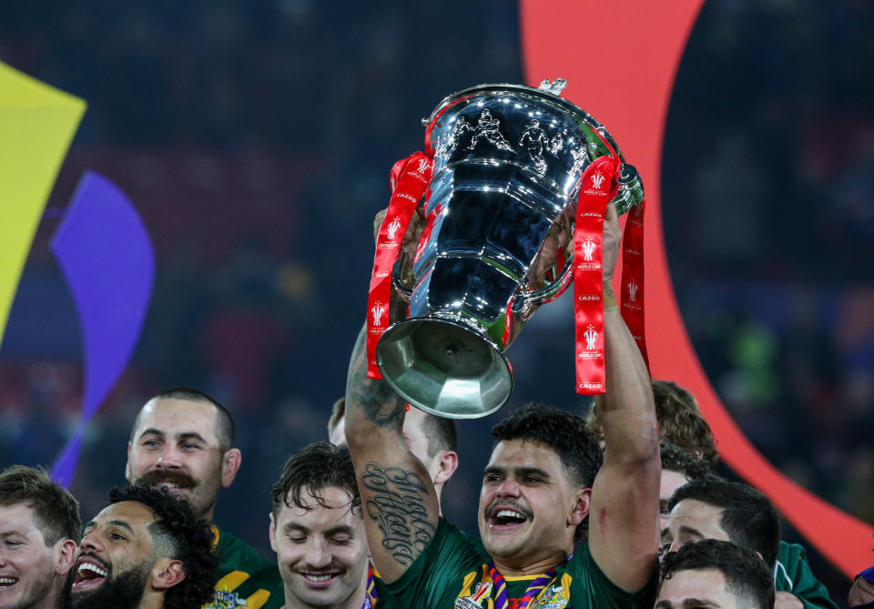 Latrell Mitchell (pictured) raises a trophy.