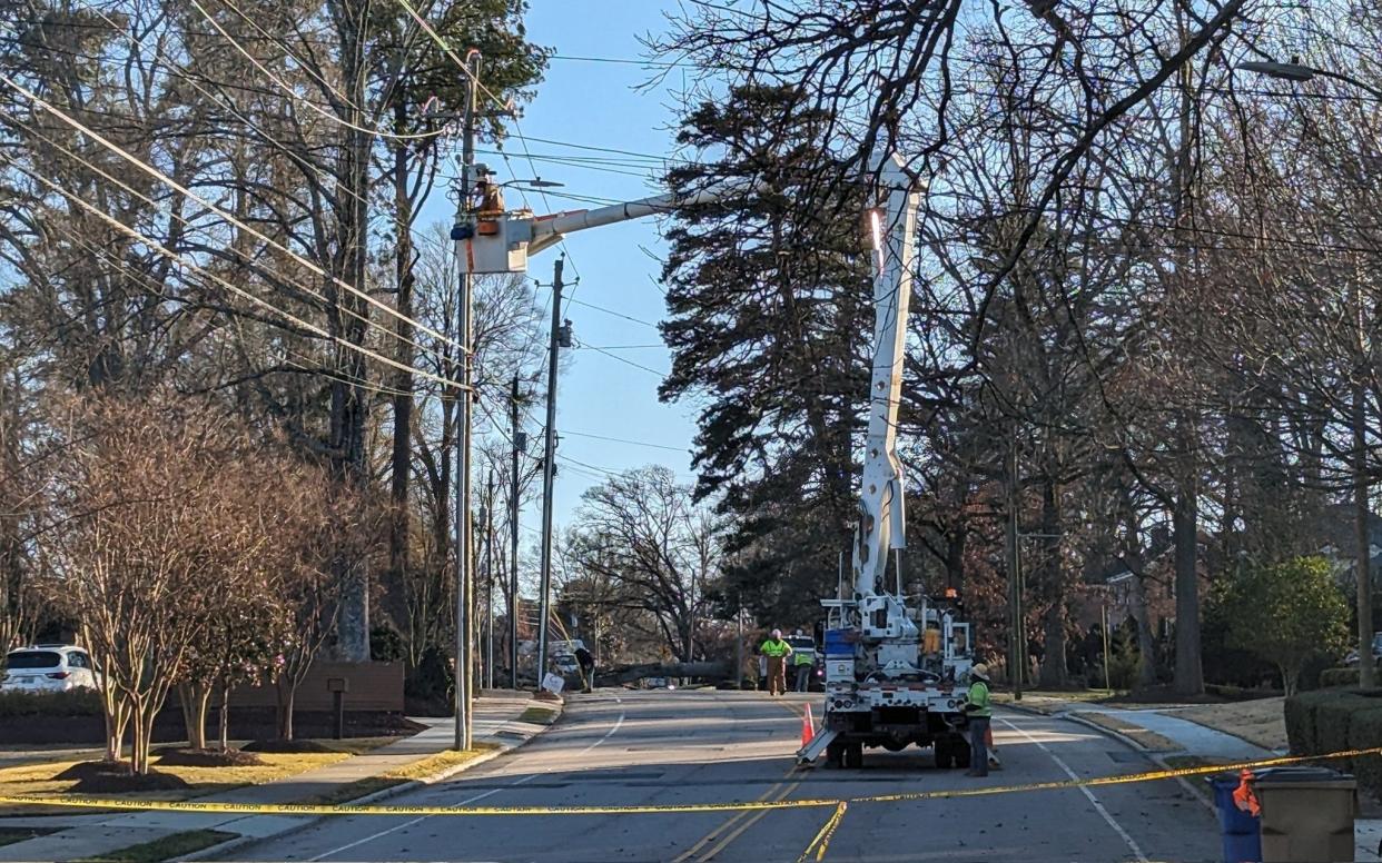 Duke Energy contractors worked to fix wind-damaged power lines in Raleigh on Dec. 23.