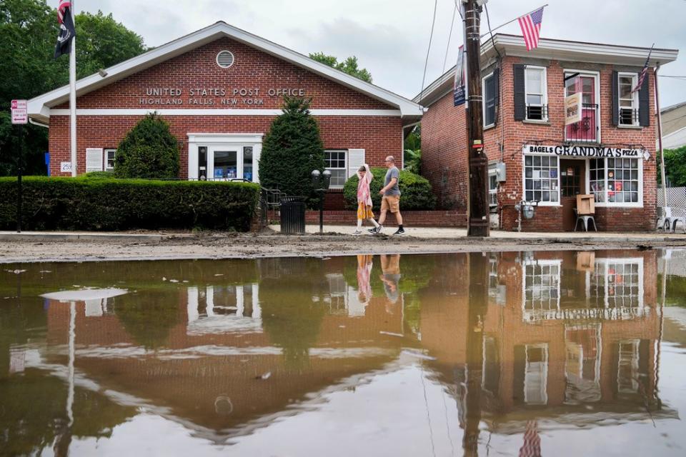 美國紐約州遭豪雨侵襲，海蘭瀑布（Highland Falls）村居民10日經過舊積水的大街。美聯社