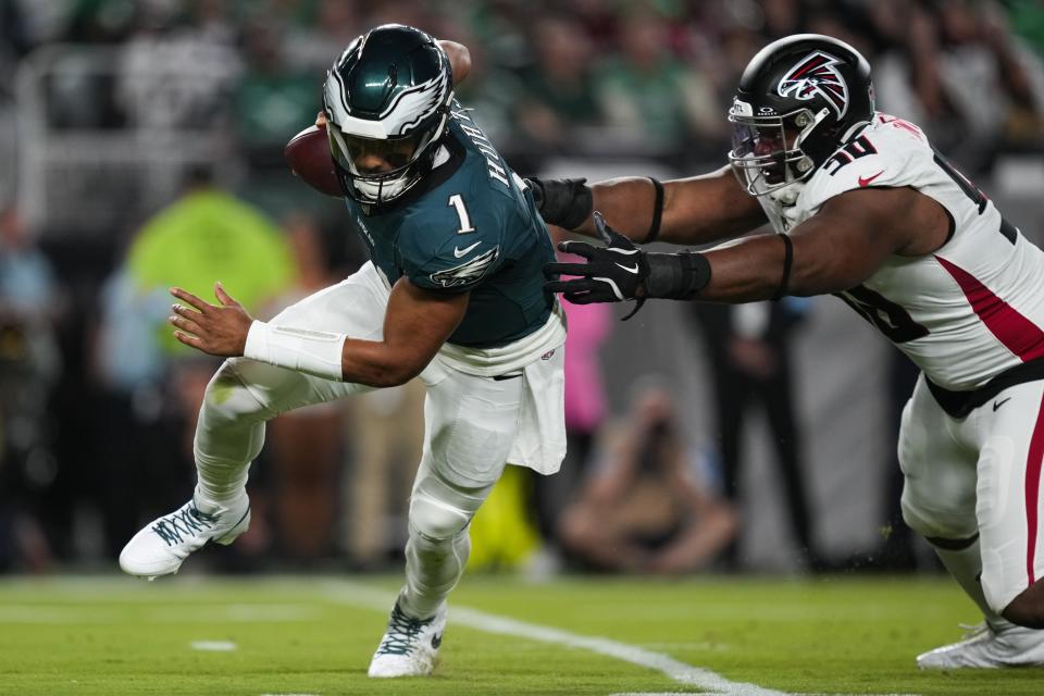 Philadelphia Eagles quarterback Jalen Hurts (1) runs past Atlanta Falcons defensive tackle David Onyemata (90) during the first half of an NFL football game Monday, Sept. 16, 2024, in Philadelphia. (AP Photo/Matt Slocum)