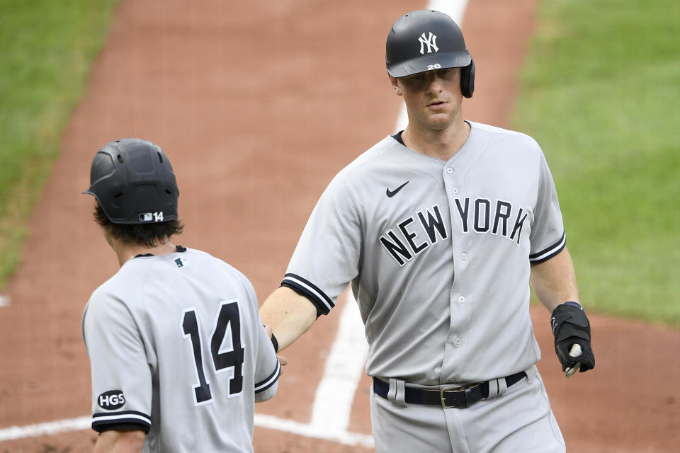 New York Yankees' DJ LeMahieu, right, is greeted by Tyler Wade (14) after they both scored a single by Brett Gardner during the third inning of the first baseball game of a doubleheader against the Baltimore Orioles, Friday, Sept. 4, 2020, in Baltimore. (AP Photo/Nick Wass)