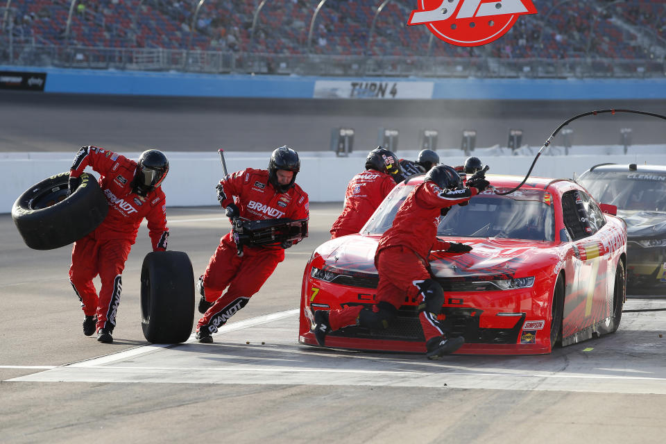 The pit crew for Justin Allgaier (7) scramble around the race car to change tires during a pit stop in a NASCAR Xfinity Series auto race at Phoenix Raceway, Saturday, Nov. 7, 2020, in Avondale, Ariz. (AP Photo/Ralph Freso)