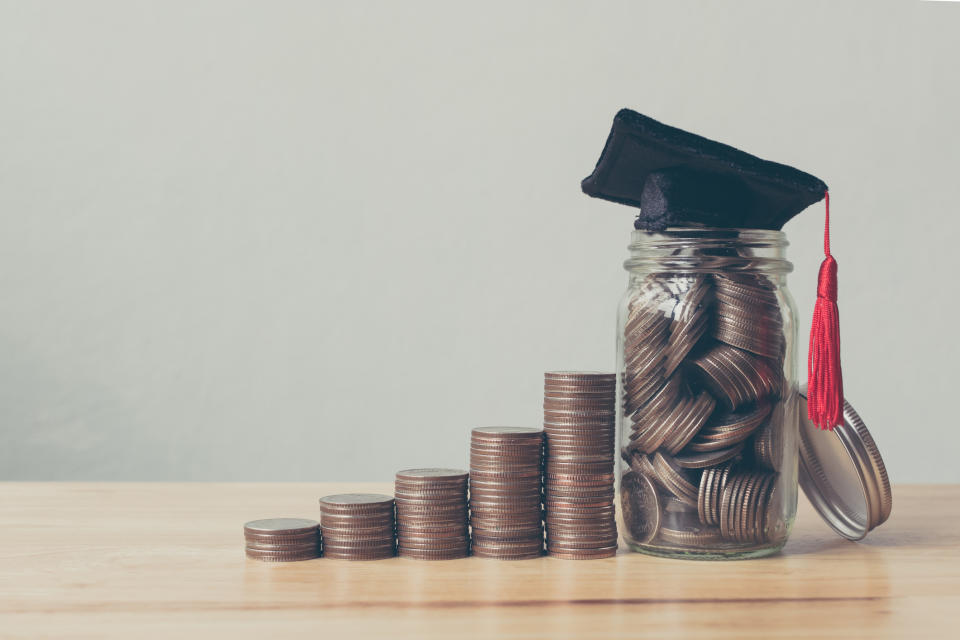 Stacks of coins leading to jar of coins for college.