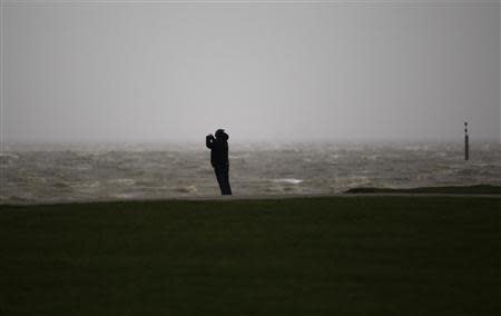 A man takes a picture on the North Sea beach near the town of Norddeich, December 5, 2013. REUTERS/Ina Fassbender