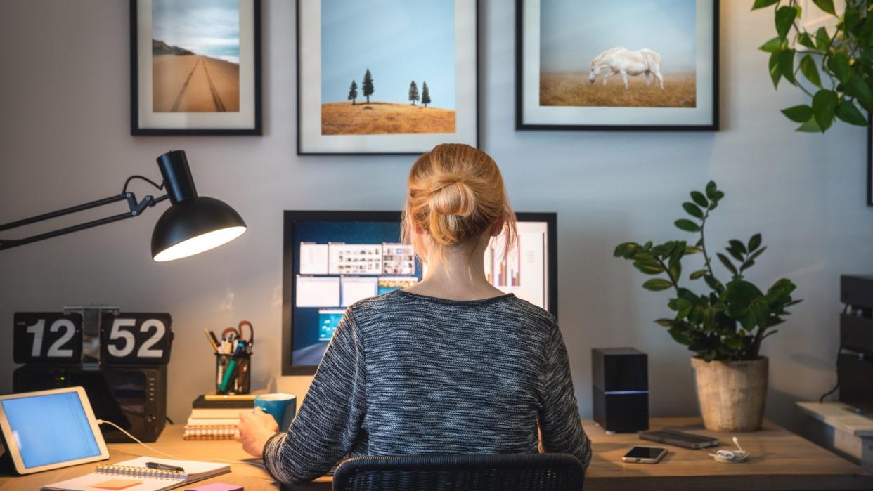 Woman working on computer in her home office during pandemic quarantine.