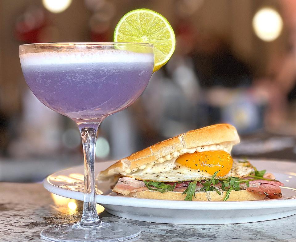 An Empress gin cocktail and a signature breakfast sandwich at the opening of The Daily Pressed on South Main Street in downtown Akron Tuesday, Feb. 7, 2023.
