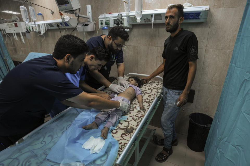 A Palestinian child wounded during an Israeli airstrike receives medical treatment at al-Aqsa hospital in Deir el-Balah, central Gaza Strip, Sunday, Oct. 15, 2023. (AP Photo/Adel Hana)