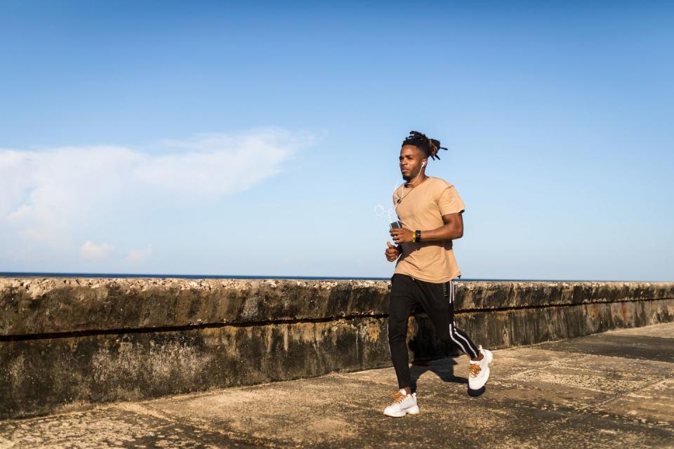 young man jogging next to sea