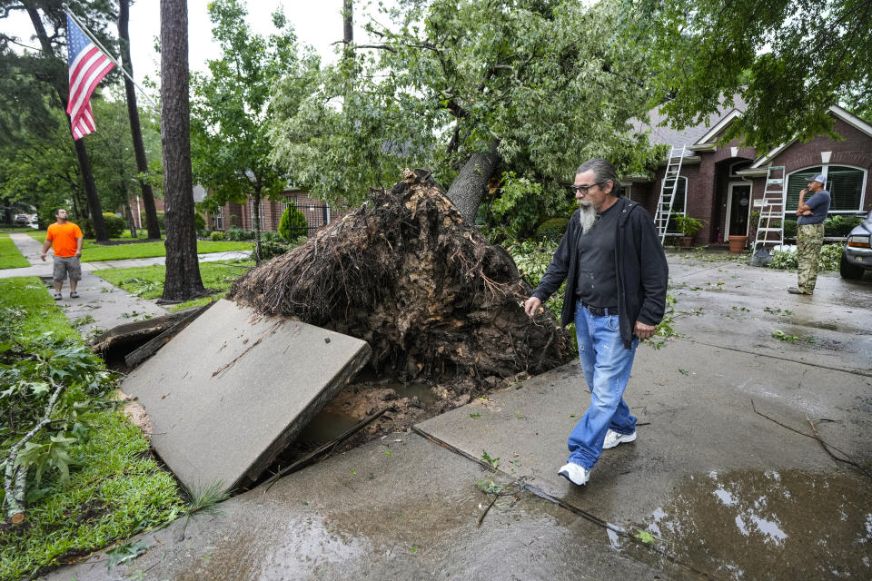 Family members survey the damage after a tree fell on the home of Monica Ramirez during a severe storm, Thursday, May 2, 2024, in Spring, Texas. (Brett Coomer/Houston Chronicle via AP)