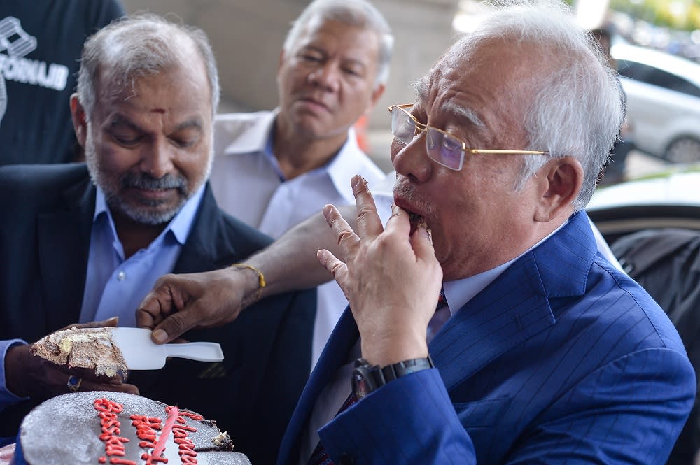 Datuk Seri Najib Razak is greeted with cheers and a chocolate cake for his 66th birthday at the lobby of the Kuala Lumpur Court Complex July 23, 2019. — Picture by Mukhriz Hazim