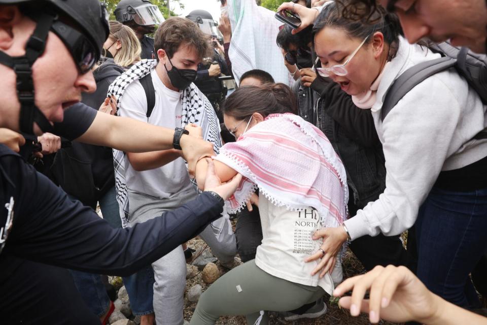 A woman is helped up after taking a fall as police pushed protesters.
