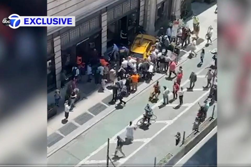 Bystanders move in to assist pedestrians who were struck by a cab that jumped a curb on Broadway ((WABC-TV via AP))