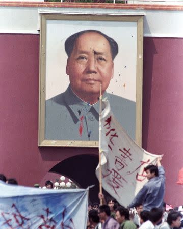 FILE PHOTO: Demonstrators in Tiananmen Square continue their protest in front of a defaced portrait of the late Chairman Mao in Beijing, China, May 23, 1989. REUTERS/Shunsuke Akatsuka/Files