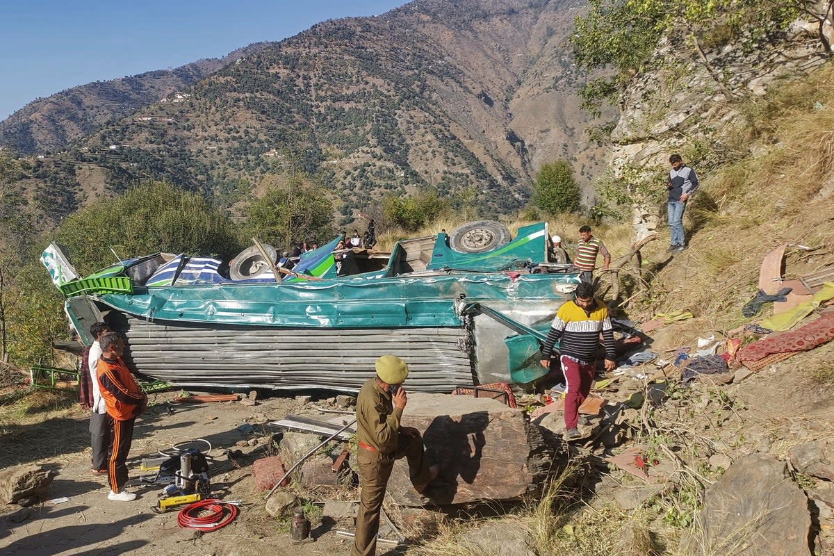 A police personnel attends a phone call near the wrecked bus, subject to an accident on a remote mountain road in the Doda area, about 200km (124 miles) southeast of the Srinagar (AFP via Getty Images)