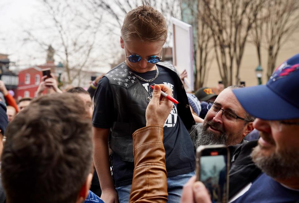 Hagerstown native Shaun Ricker, aka WWE's LA Knight, reaches up to autograph a young man's LA Knight jacket Saturday during a gathering in University Park where city officials presented Ricker with a key to the city.