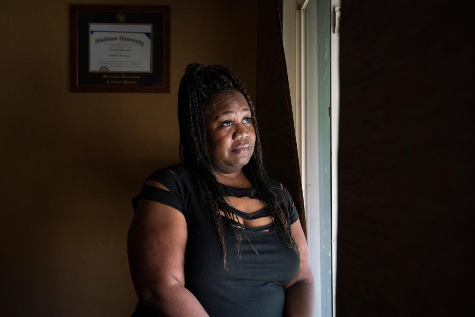 Tenai Leali, 47, of Detroit, stands next to a window in her home in Detroit on Sept. 27, 2022. Leali inherited her grandparent's home but has been trying to get the house in her name since 2020. "It's been so frustrating," said Leali who is afraid of losing the property.