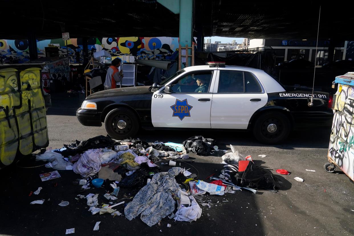 A San Francisco Police Department vehicle drives through a homeless encampment being cleaned up in San Francisco, Tuesday, Aug. 29, 2023. Cities across the U.S. are struggling with and cracking down on tent encampments as the number of homeless people grows, largely due to a lack of affordable housing. Homeless people and their advocates say sweeps are cruel and costly, and there aren't enough homes or beds for everyone. (AP Photo/Jeff Chiu)