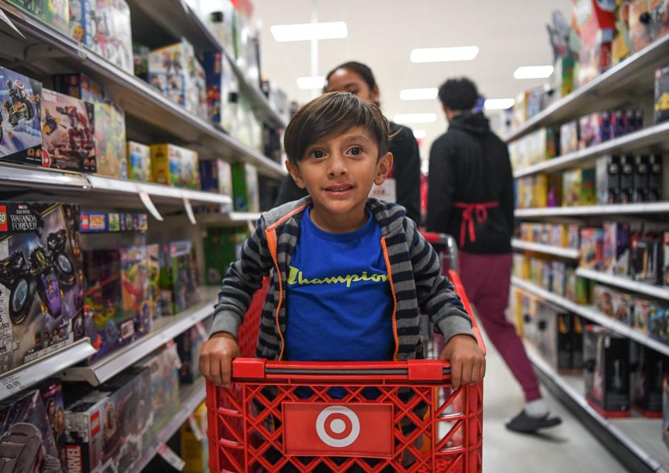 Eli Moreno, helped by volunteer Micah McGill, looks for toys during the 26th annual Weigel's Family Christmas.