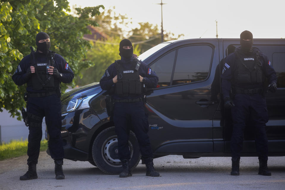 Police officers block the street near the scene of a Thursday night attack in the village of Dubona, some 50 kilometers (30 miles) south of Belgrade, Serbia, Friday, May 5, 2023. A shooter killed multiple people and wounded more in a drive-by attack late Thursday in Serbia's second such mass killing in two days, state television reported. (AP Photo/Armin Durgut)